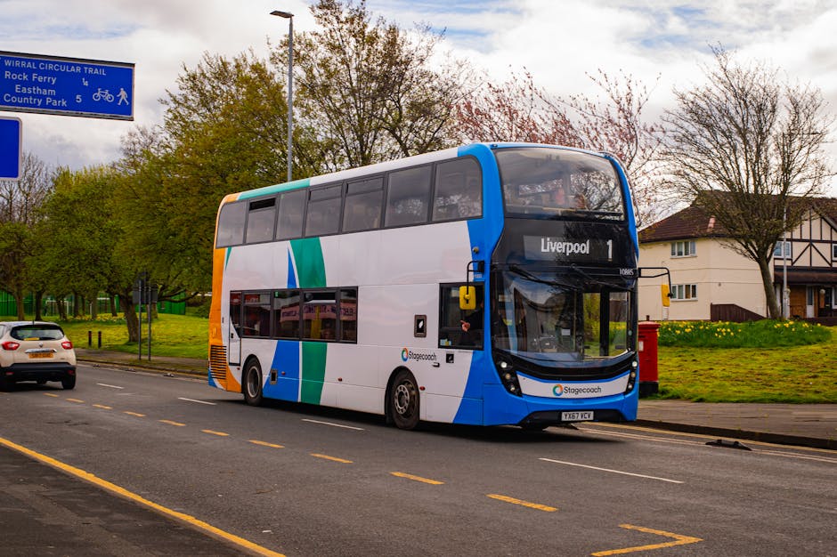 A double-decker Stagecoach bus with a white, blue, green, and orange livery is parked alongside a residential street near a pavement. The bus is displaying the destination 'Liverpool 1' on its front.